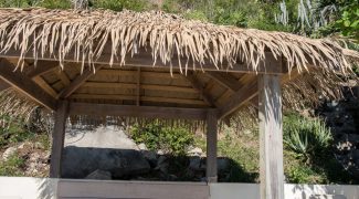 Straw palapa covering an outdoor lounge.